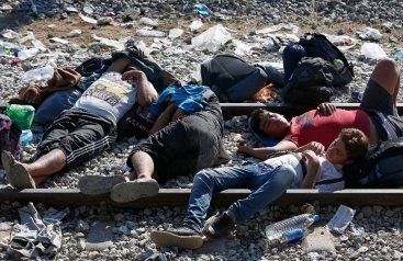 Migranti siriani dormono sulle rotaie nei pressi di Idomeni, in Grecia