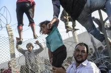 Bulent Kilic, Turchia, Agence France-Presse Confine spezzato. Rifugiati cercando di oltrepassare una recinzione per entrare illegalmente dalla Siria alla Turchia, non lontano dalla città di Akcakale, 14 giugno 2015.